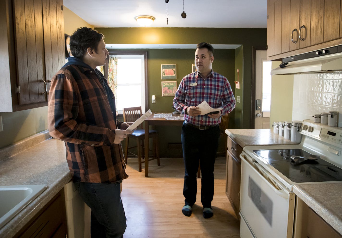 Real estate agent Dan Winters, right, chatted in the kitchen with his client, Dustin Corder, while viewing a home in Columbia Heights earlier this month.