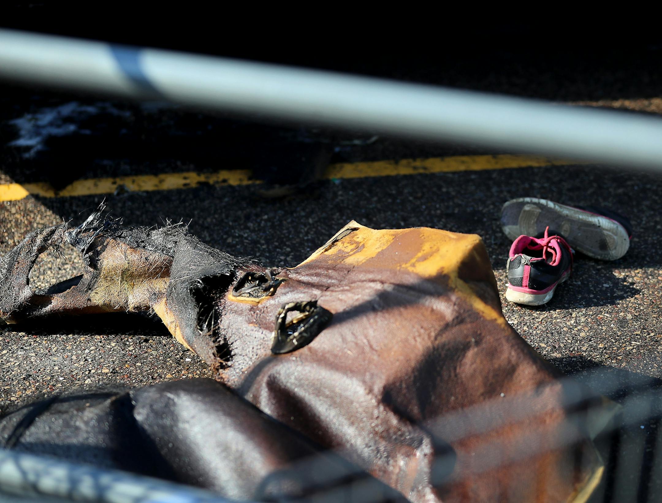 A car fire at a Fridley Walmart engulfed three vehicles and left two young passengers injured in a taxi van parked next to the vehicle where the fire originated Tuesday, Aug. 6, 2019, in Fridley, MN. A pair of shoes sit outside a charred van where two children were injured in the fire.