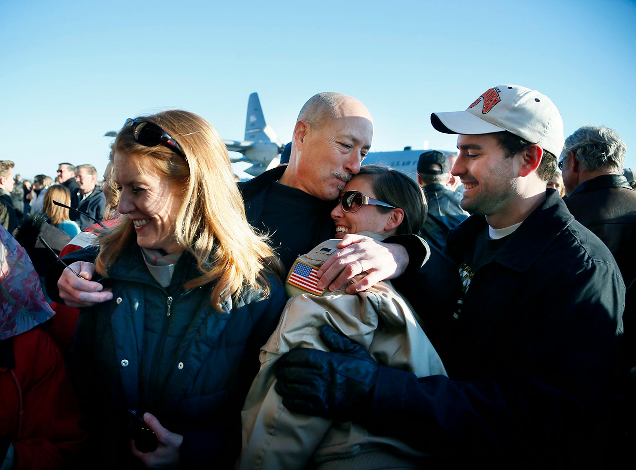 Jim Perry (center) hugged his daughter Lt. Alicia Makoutz , his wife Lori Perry left and Alicia husband Chris Makoutz looked on. Families gather for the arrival of the more than 100 Airmen and three C-130 H3 Hercules aircraft from the 934th Airlift Wing, Air Force Reserve, return from their deployment to Southwest Asia after their four-month tour of duty. Sunday January 18, 2015 Minneapolis, MN.] Jerry Holt/ Jerry.Holt@Startribune.com