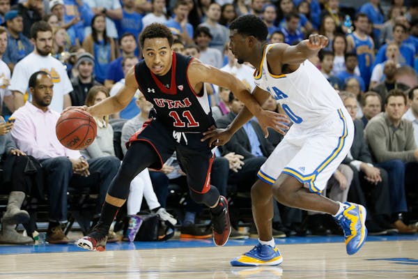 Utah's Brandon Taylor, left, dribbles as UCLA's Isaac Hamilton, right, defends him during the first half of an NCAA college basketball game Thursday, 
