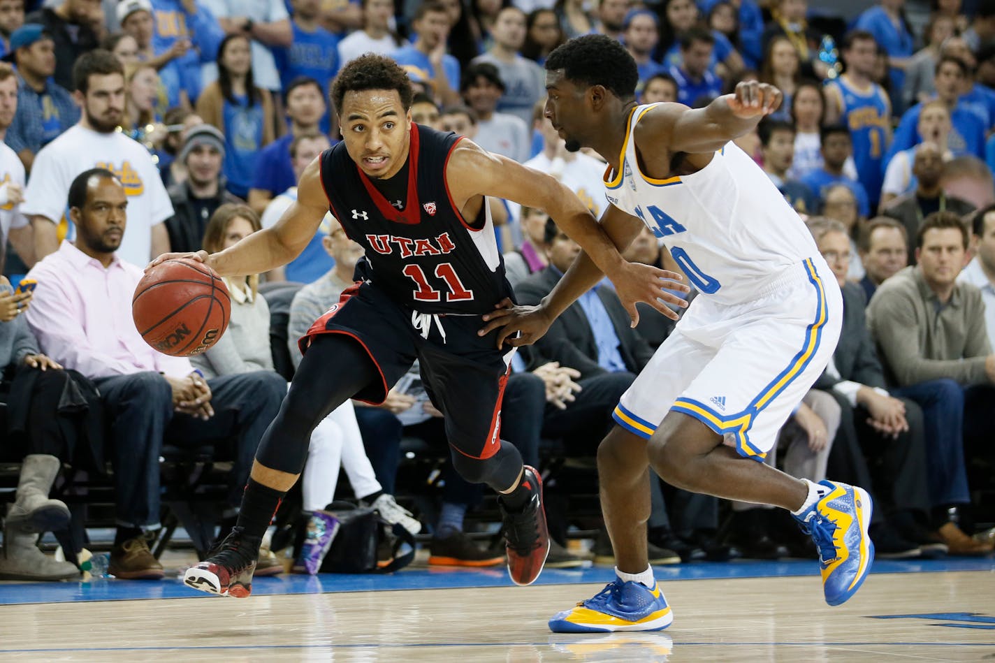 Utah's Brandon Taylor, left, dribbles as UCLA's Isaac Hamilton, right, defends him during the first half of an NCAA college basketball game Thursday, Jan. 29, 2015, in Los Angeles. (AP Photo/Danny Moloshok)