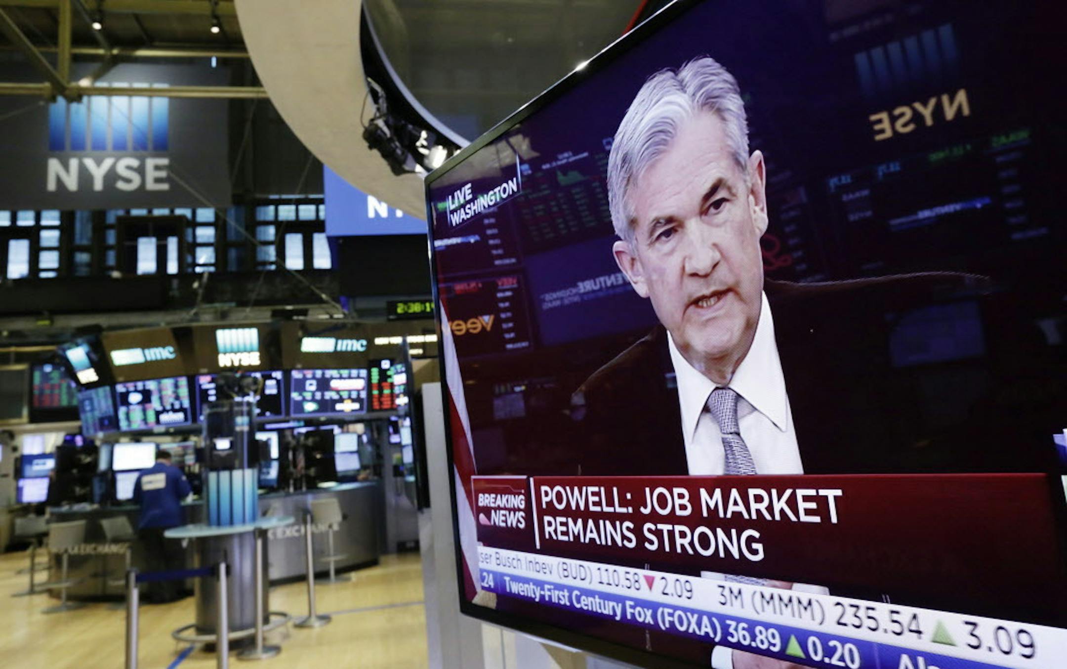 The Washington news conference of Federal Reserve Chairman Jerome Powell appears on a television on the floor of the New York Stock Exchange, Wednesday, March 21, 2018. The Federal Reserve is raising its benchmark interest rate to reflect a solid U.S. economy and signaling that it's sticking with a gradual approach to rate hikes for 2018 under its new chairman. (AP Photo/Richard Drew)