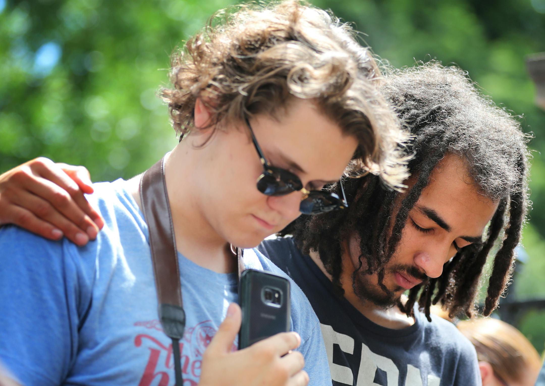 Maxwell Silver, left, 19, and Elijah Lartey, 19, both of St. Paul, observe a moment of silence together outside the governor's residence. ] (Leila Navidi/Star Tribune) leila.navidi@startribune.com BACKGROUND INFORMATION: Protesters at the governor's residence in St. Paul on Thursday, July 7, 2016, one day after Philando Castile of St. Paul died after being shot by police in Falcon Heights, the aftermath of which was recorded in a video widely shared on Facebook.