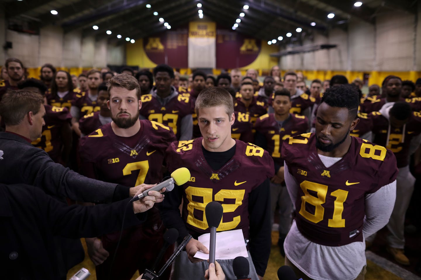 Wide receiver Drew Wolitarsky, center, flanked by quarterback Mitch Leidner, left, and tight end Duke Anyanwu, and with the rest of the team standing behind them, read the statement on behalf of the players.