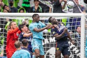 Seattle goalkeeper Stefan Frei, left, had help from two defenders in thwarting a Loons attack in the second half of the Sounders’ 3-1 victory over M