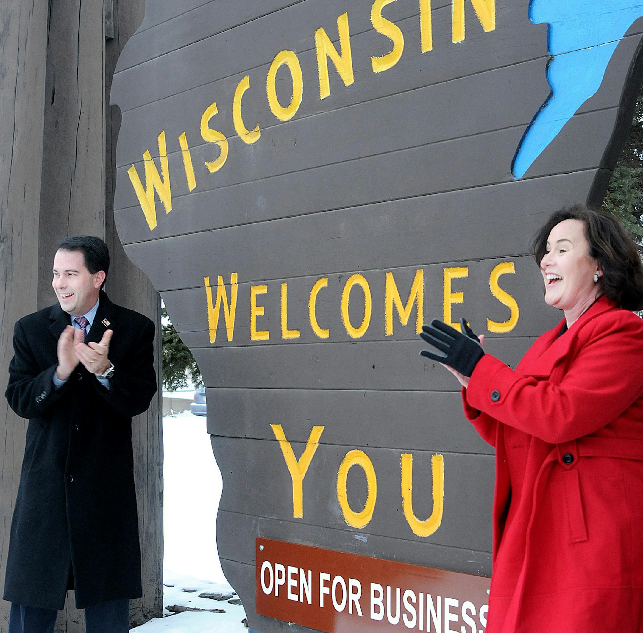 In this photo taken Jan. 18, 2011, Wisconsin Gov. Scott Walker and Wisconsin Secretary of Tourism Stephanie Klett celebrate after placing the new ‚ÄúOpen for Business‚Äù sign on the "Wisconsin Welcomes You" sign at the base of the Blatnik Bridge in Superior, Wis. (AP Photo/The Daily Telegram, Jed Carlson) ORG XMIT: WISUP101 ORG XMIT: MIN1310111133164577