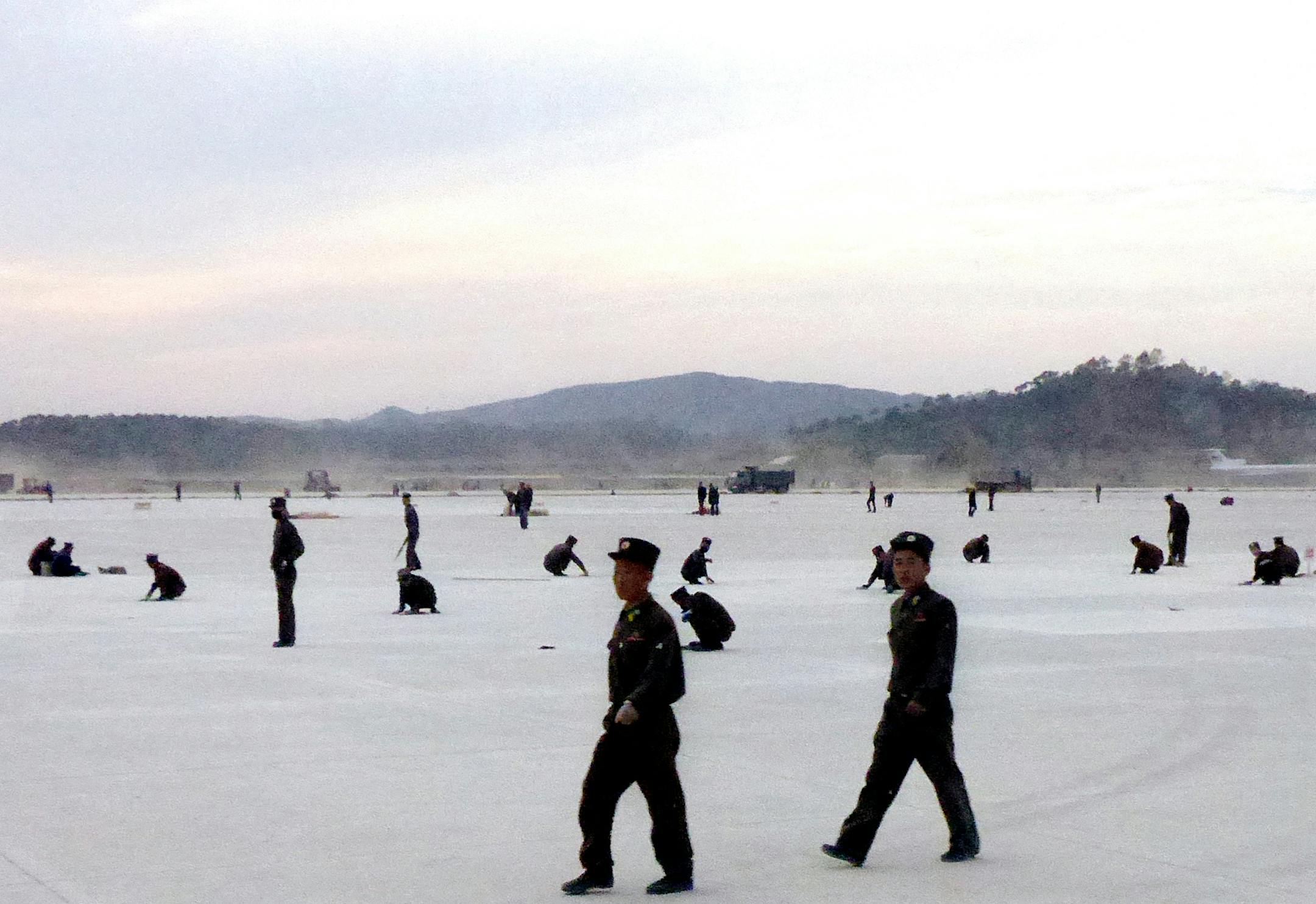 This photograph taken on Tuesday, Oct. 21, 2014, North Korean soldier-builders work on the new tarmac of Sunan International Airport in Pyongyang, North Korea. The new airport, which is now in its final stages, is the latest of North Korea's "speed campaigns," mass mobilizations of labor shock brigades aimed at finishing top-priority projects in record time. (AP Photo/Wong Maye-E)