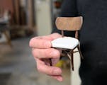 Furniture designer/maker Willie Willette holds a miniature model of a custom walnut chair at his wood shop and studio in Minneapolis in 2018.