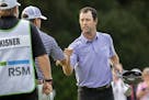 Robert Streb, right, fist-bumps Kevin Kisner after winning a second hole playoff at the RSM Classic golf tournament, Sunday, Nov. 22, 2020, in St. Sim