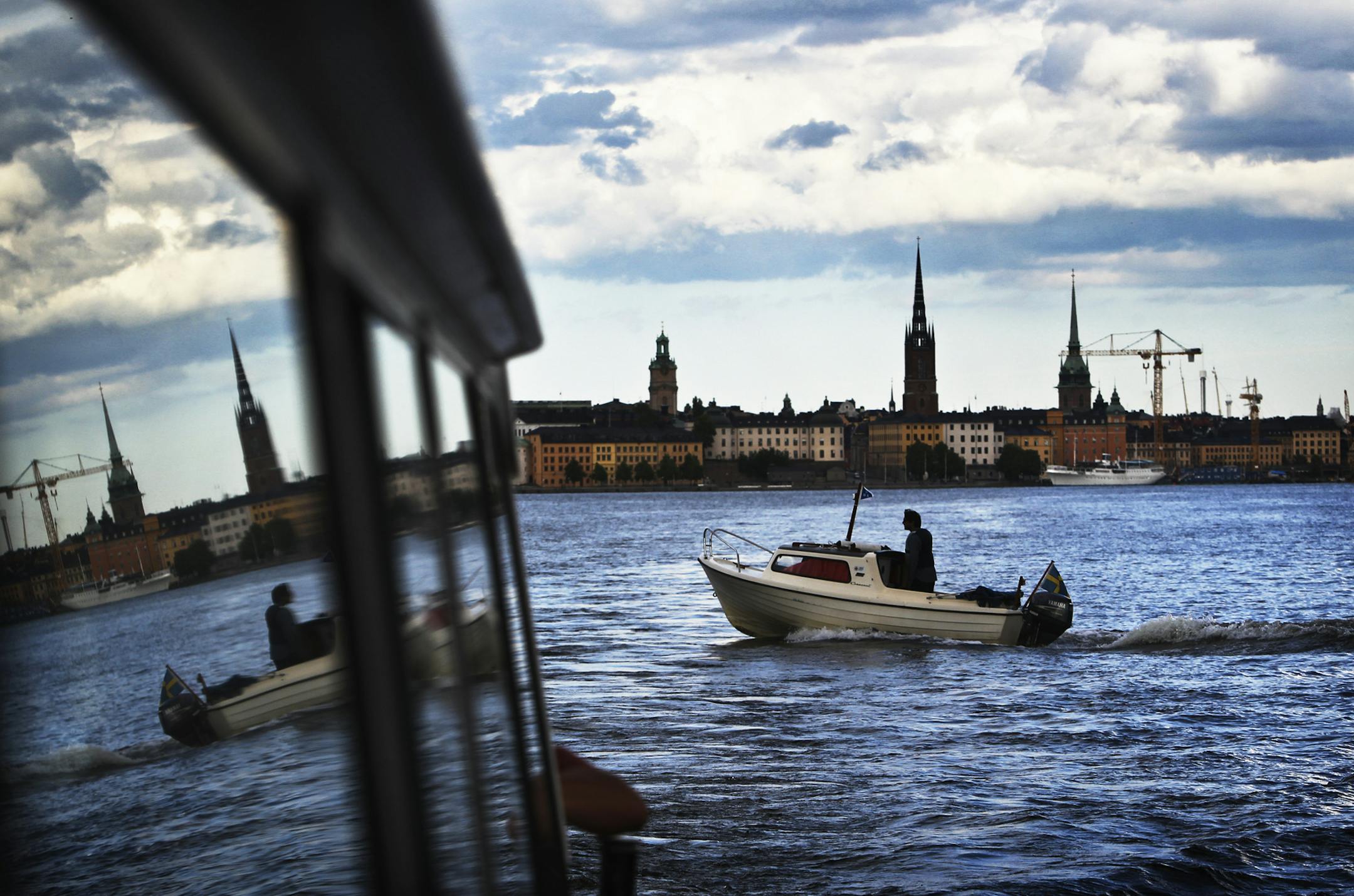 A passing boat and Stockholm's Old Town are seen reclected in the window of a ferry during a water tour of the city in Stockholm, Sweden Saturday, June 30, 2012. ](DAVID JOLES/STARTRIBUNE) djoles@startribune.com Travel story on Sweden