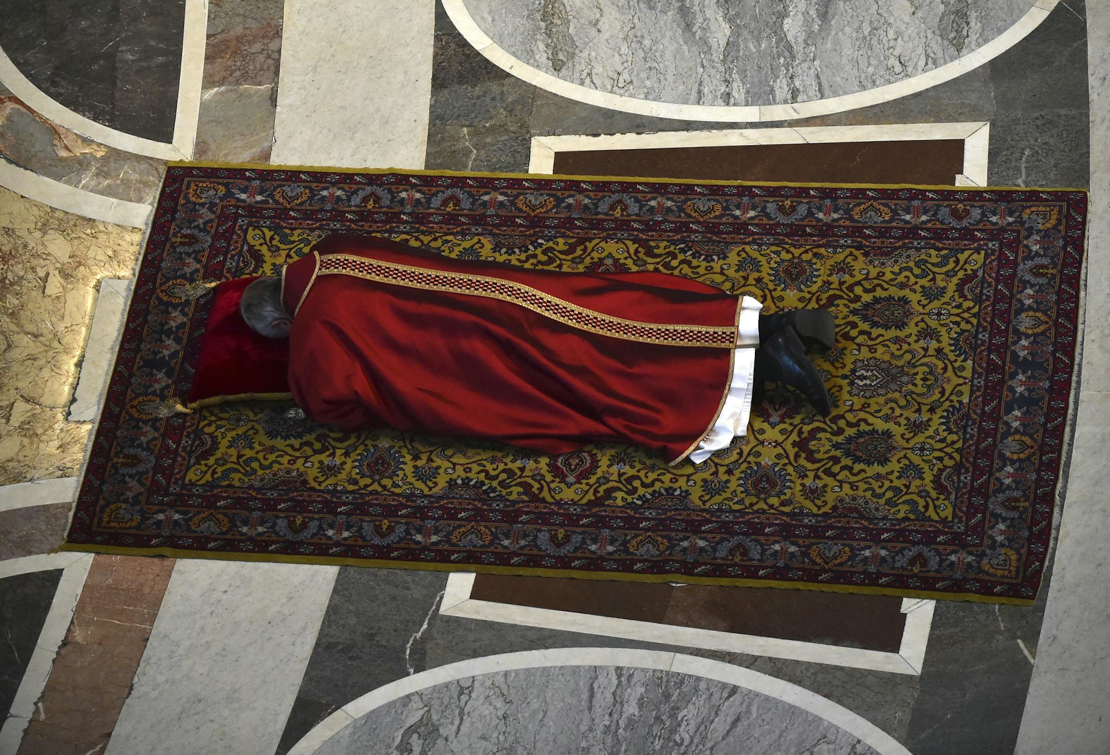 Pope Francis lies on the floor during a mass to celebrate the Lord's Passion, in St. Peter's basilica at the Vatican, Friday, April 3, 2015. (AP Photo/Gabriel Bouys, Pool)