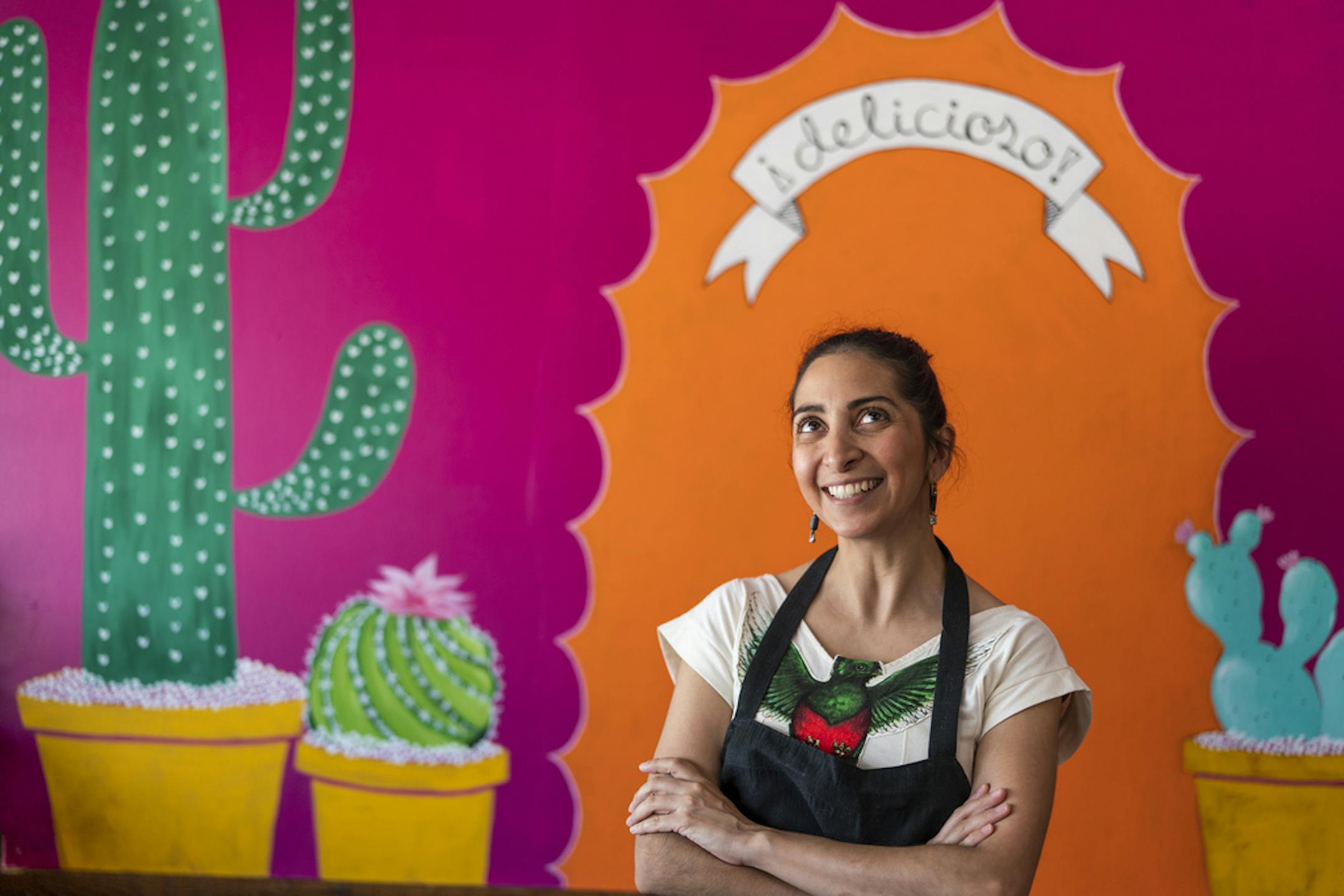 Dulce Monterrubio, the owner of Dulceria Bakery, at her Minneapolis bakery cafe in front of a mural painted by her 17-year-old daughter Sofia Haase-Oliva.