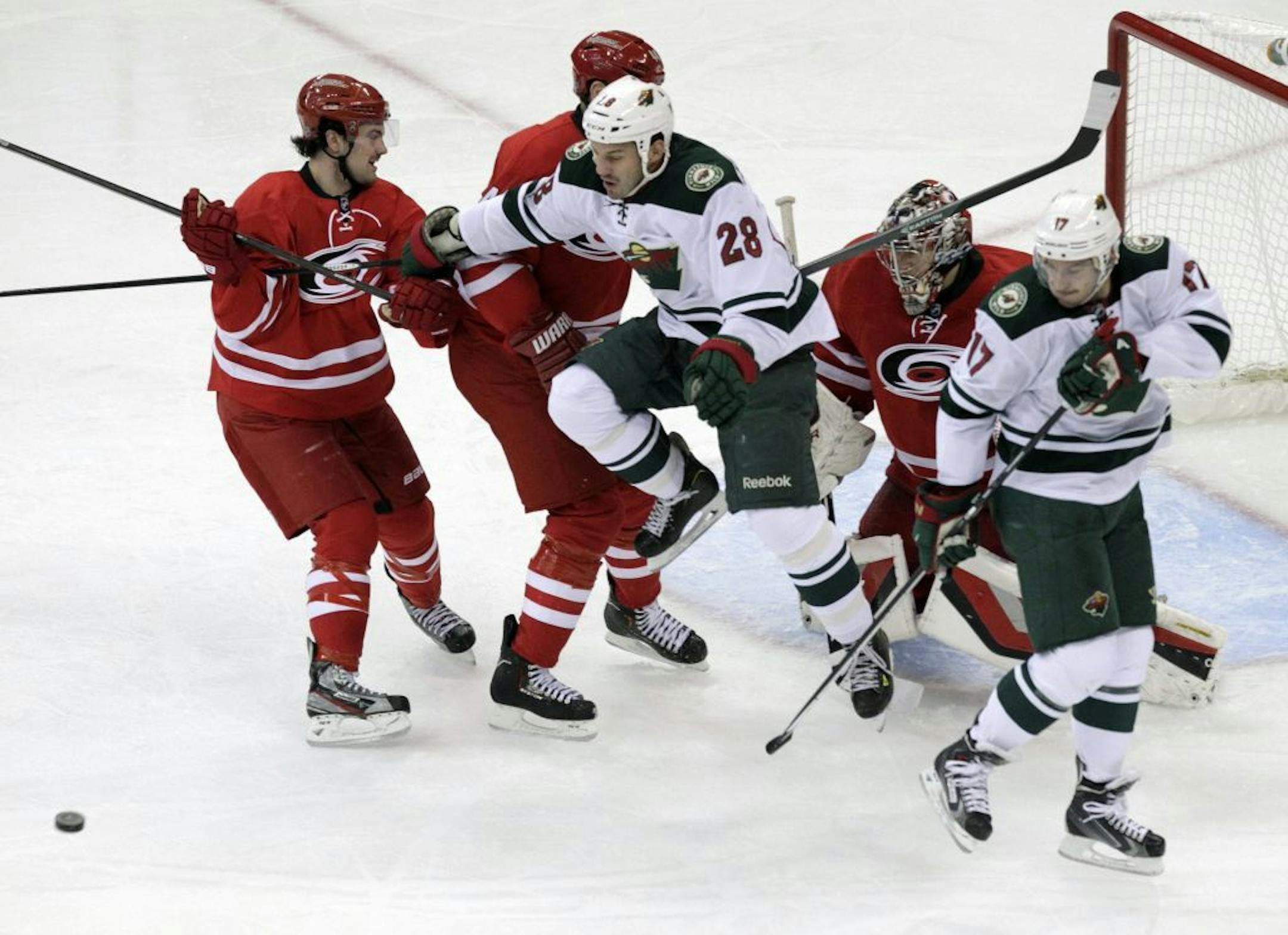 Ryan Murphy (7), Jay Harrison (44) and Justin Peters (35) of the Carolina Hurricanes defend the goal against the Zenon Konopka (28) and Torrey Mitchell (17) of the Minnesota Wild during the second period at the PNC Arena in Raleigh, N.C., on Saturday, Nov. 9, 2013.