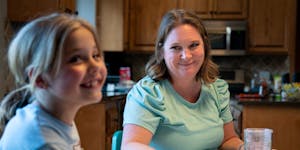 Ellie, 7, eats dinner with her mother, Meta Getman, at their home in Eden Prairie. Meta, a fertility coach, gave birth to Ellie and her twin, Addie, t