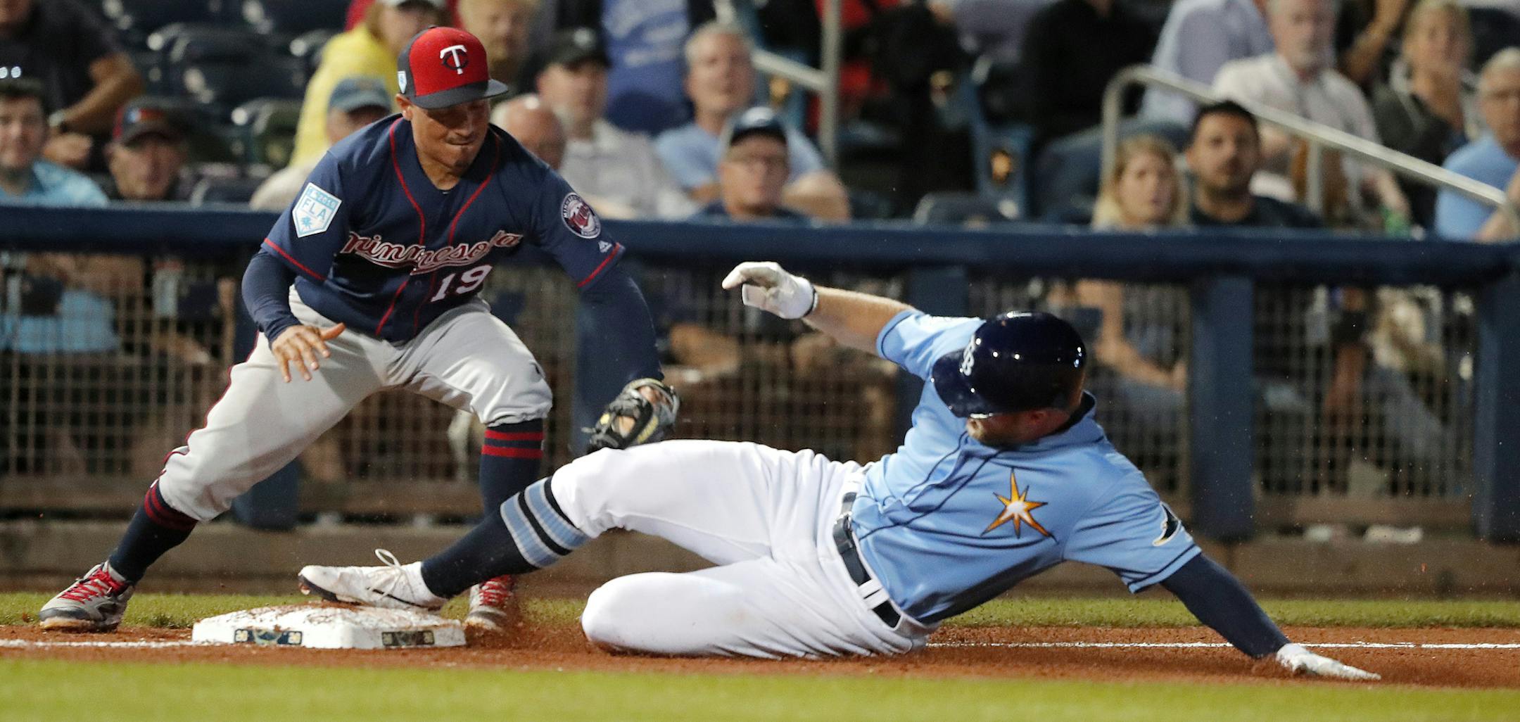 Tampa Bay Rays' Austin Meadows advances to third base as Minnesota Twins' Ronald Torreyes (19) tries to make the tag during the sixth inning of a spring training baseball game in Port Charlotte, Fla., Thursday, Feb. 28, 2019. (AP Photo/Gerald Herbert)