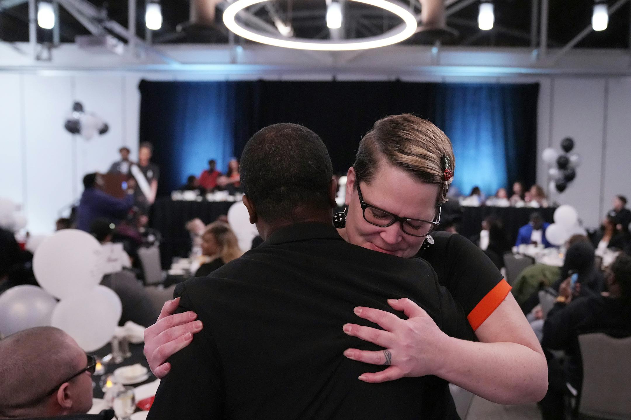 Brooklyn Center Mayor Mike Elliott gets a hug from Courteney Ross, George Floyd's former girlfriend, during an event to mark one year since Daunte Wright was fatally shot by former Brooklyn Center officer Kimberly Potter.