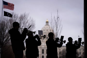 An ensemble of trumpets, who are also veterans, play America the Beautiful at the conclusion of the program on the grounds of the State Capitol in St.