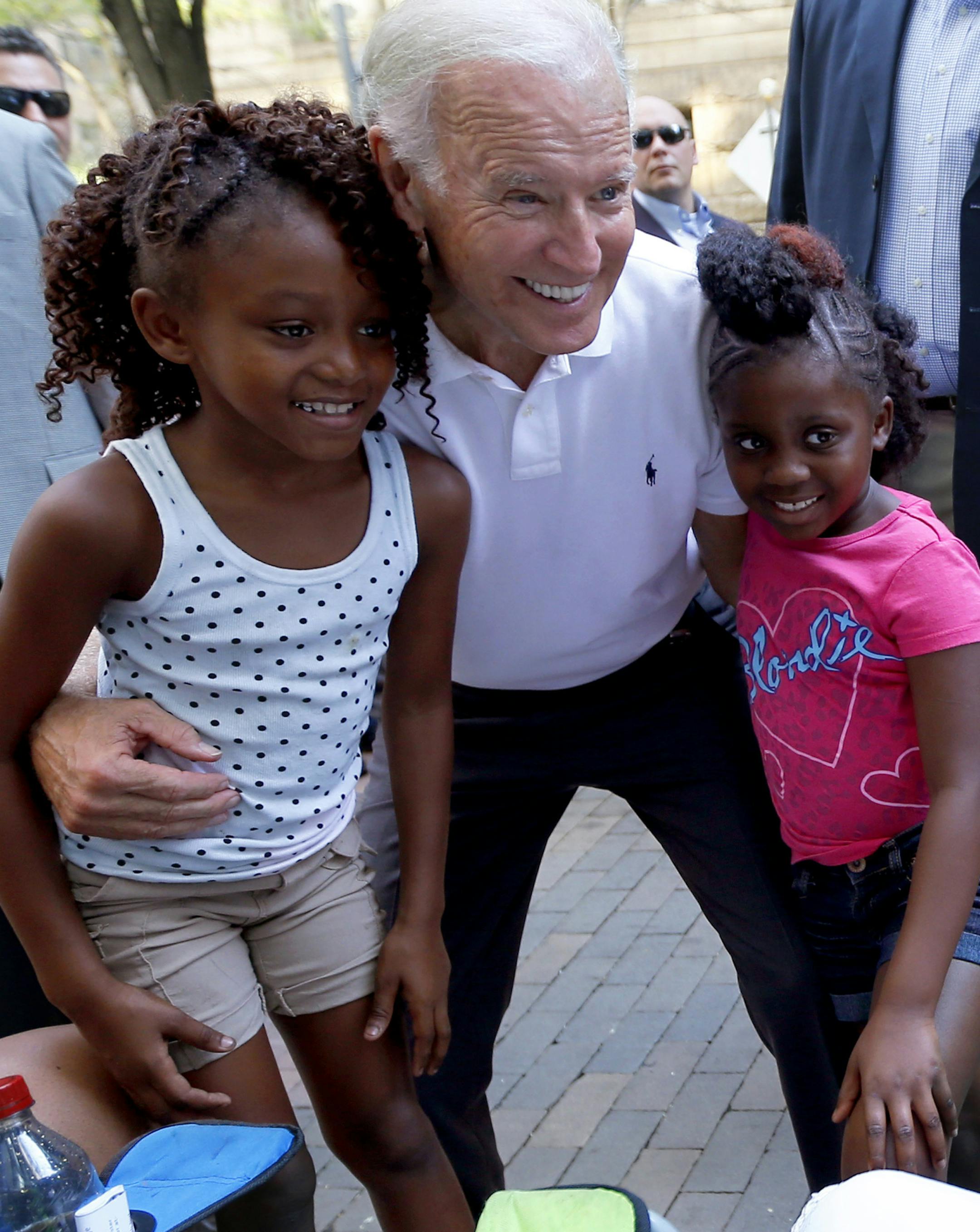 Vice President Joe Biden pose with Brooklyn, left, and Kemora Holley as their mother, Linda Holley, right, takes their picture as Biden walks in the annual Labor Day parade on Monday, Sept. 7, 2015, in Pittsburgh. (AP Photo/Keith Srakocic)