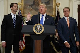 President Donald Trump, flanked by Sen. Tom Cotton, R- Ark., left, and Sen. David Perdue, R-Ga., speaks in the Roosevelt Room of the White House in Wa