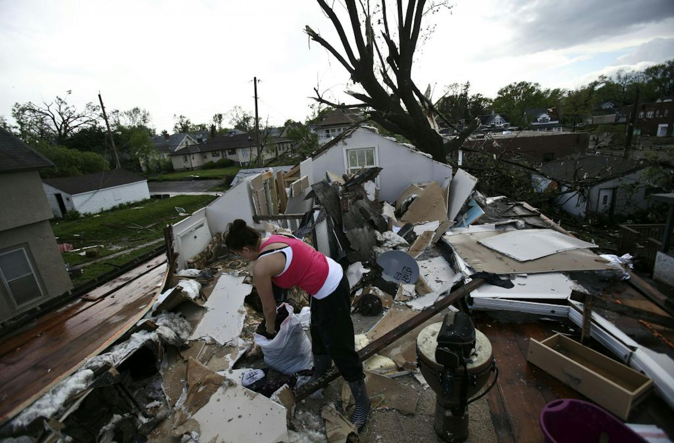 Heather Carufel went through what was left of her belongings after a tornado ripped the roof off of the room she was renting in North Minneapolis on Emerson Ave near 37th Street . Carufel was in the shower when the tornado hit so she had to borrow the clothes she's wearing.
