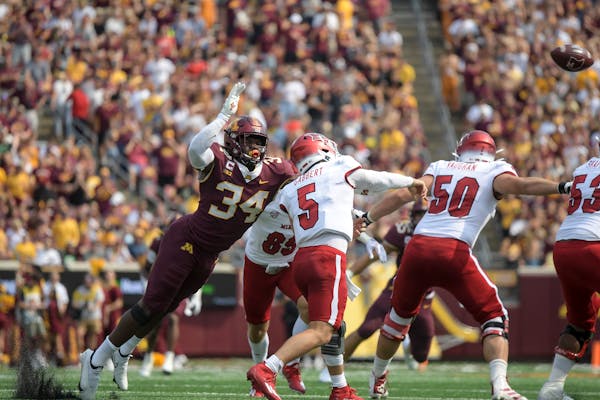 Minnesota Gophers defensive lineman Boye Mafe (34) attempted to tackle Miami (Oh) Redhawks quarterback Brett Gabbert (5) as he released the ball in th