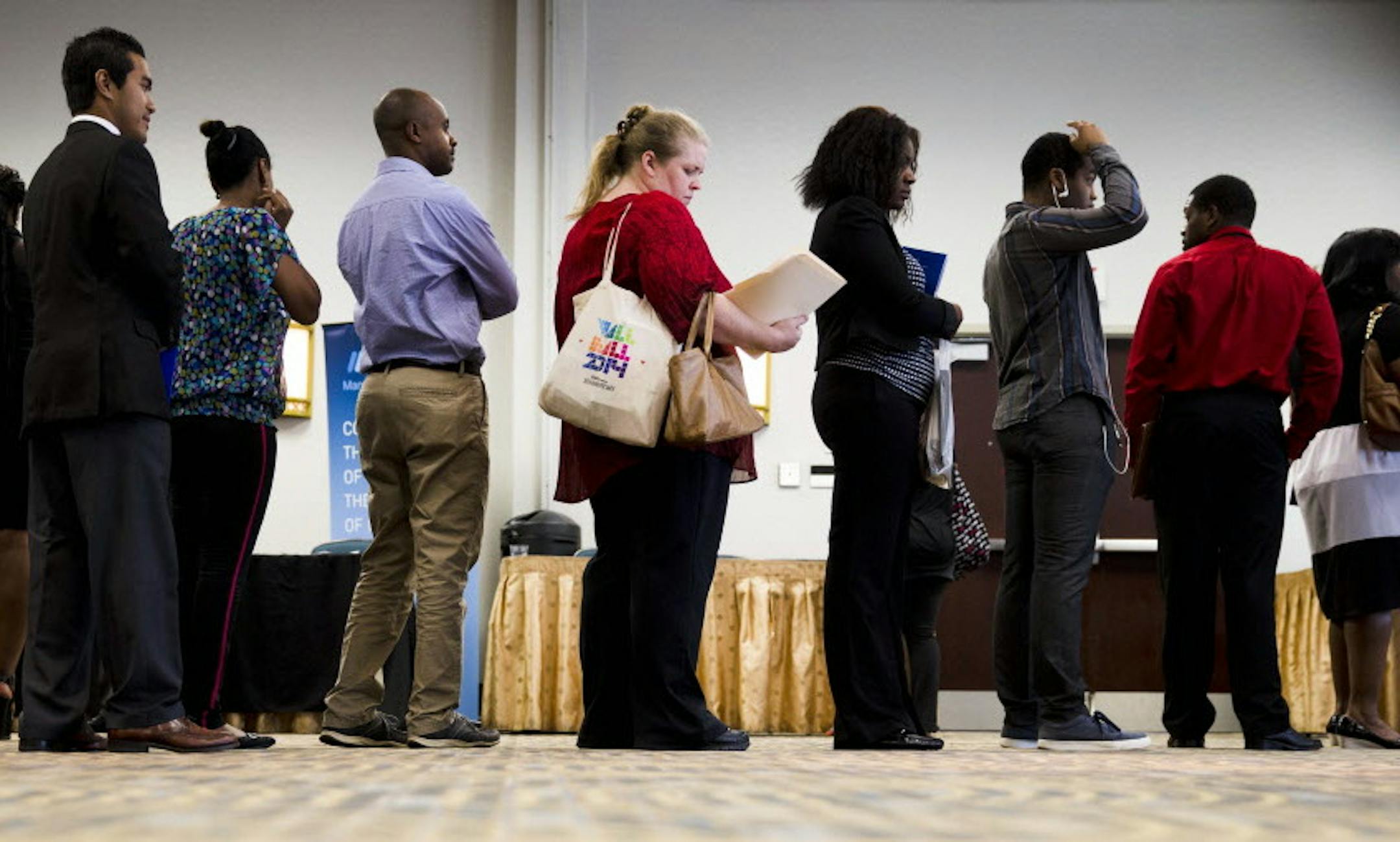 In this June 23, 2014 photo, job seekers wait in line to meet with recruiters during a job fair in Philadelphia. The government issues the July jobs report on Friday, Aug. 1, 2014. (AP Photo/Matt Rourke)