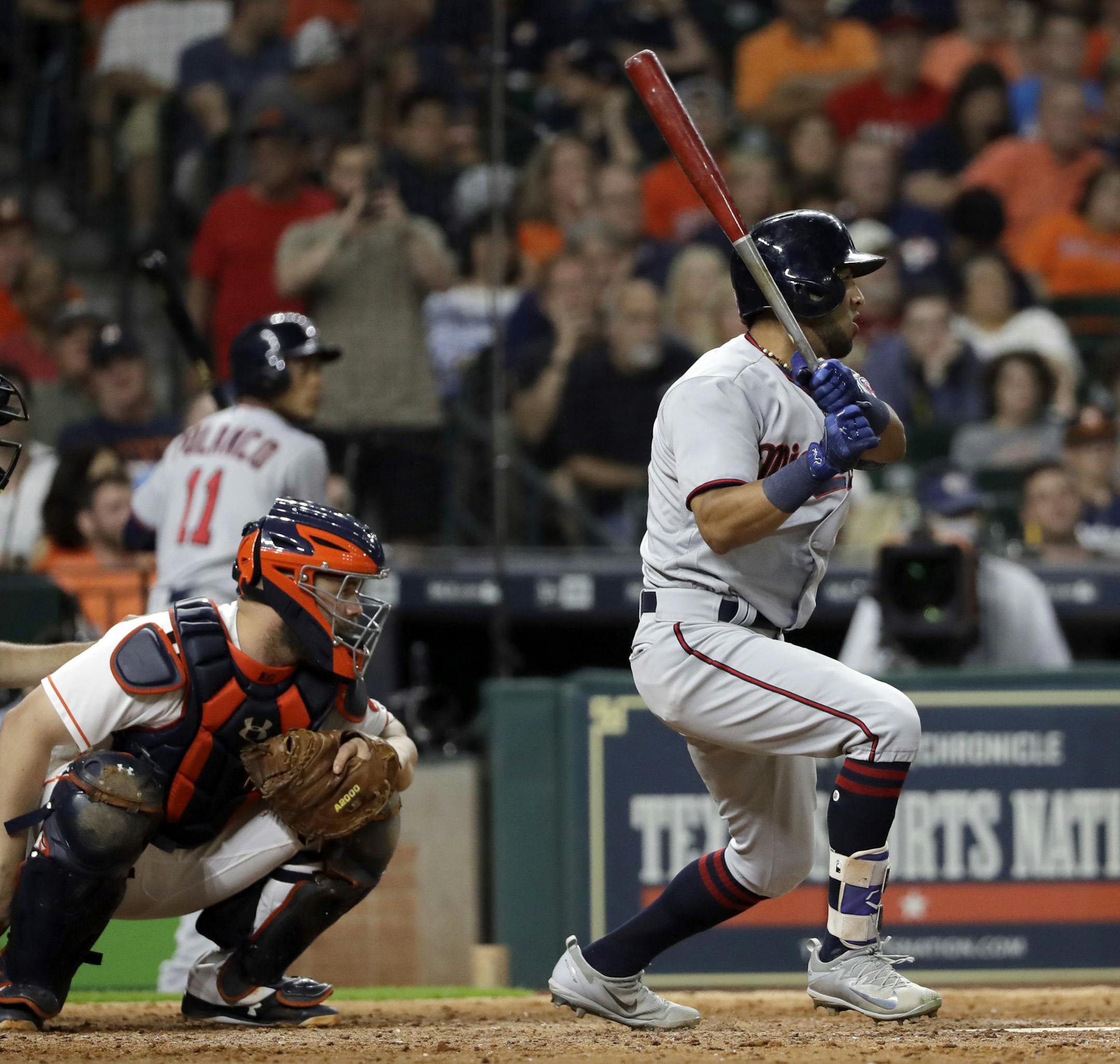 Minnesota Twins' Eddie Rosario, right, watches his single along with Houston Astros catcher Evan Gattis during the eighth inning of a baseball game Saturday, July 15, 2017, in Houston. (AP Photo/David J. Phillip)