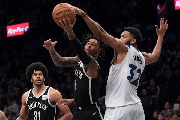 Brooklyn guard D'Angelo Russell (1) goes to the basket against Timberwolves center Karl-Anthony Towns on Friday.