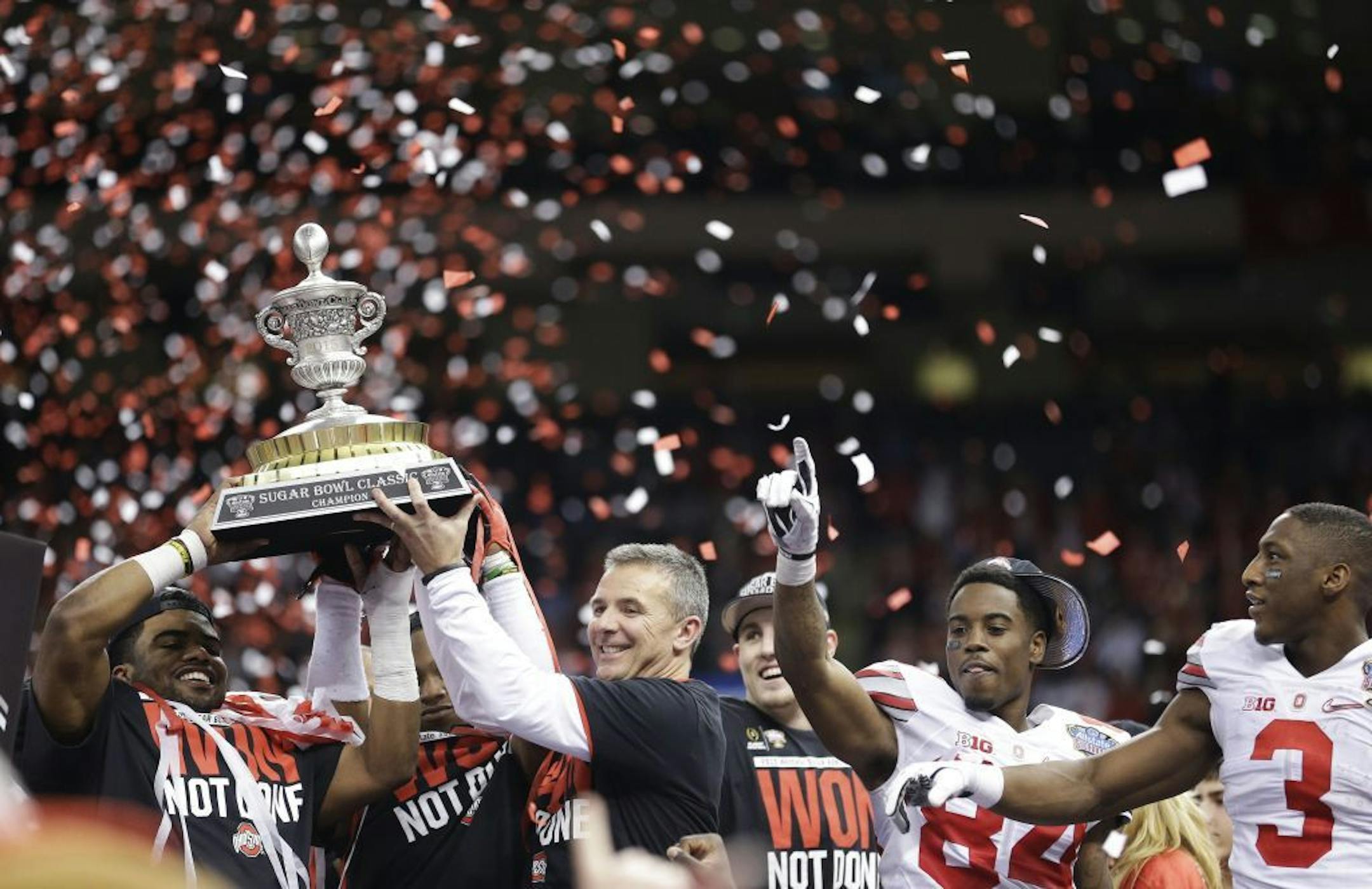 Ohio State players and staff hold the Sugar Bowl Classic trophy after the Sugar Bowl NCAA college football playoff semifinal game against Alabama, Friday, Jan. 2, 2015, in New Orleans. Ohio State won 42-35.
