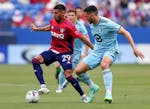 FC Dallas' Franco Jara (29) tries to go around Minnesota United defender Michael Boxall during the first half of an MLS soccer game, Sunday, May 22, 2