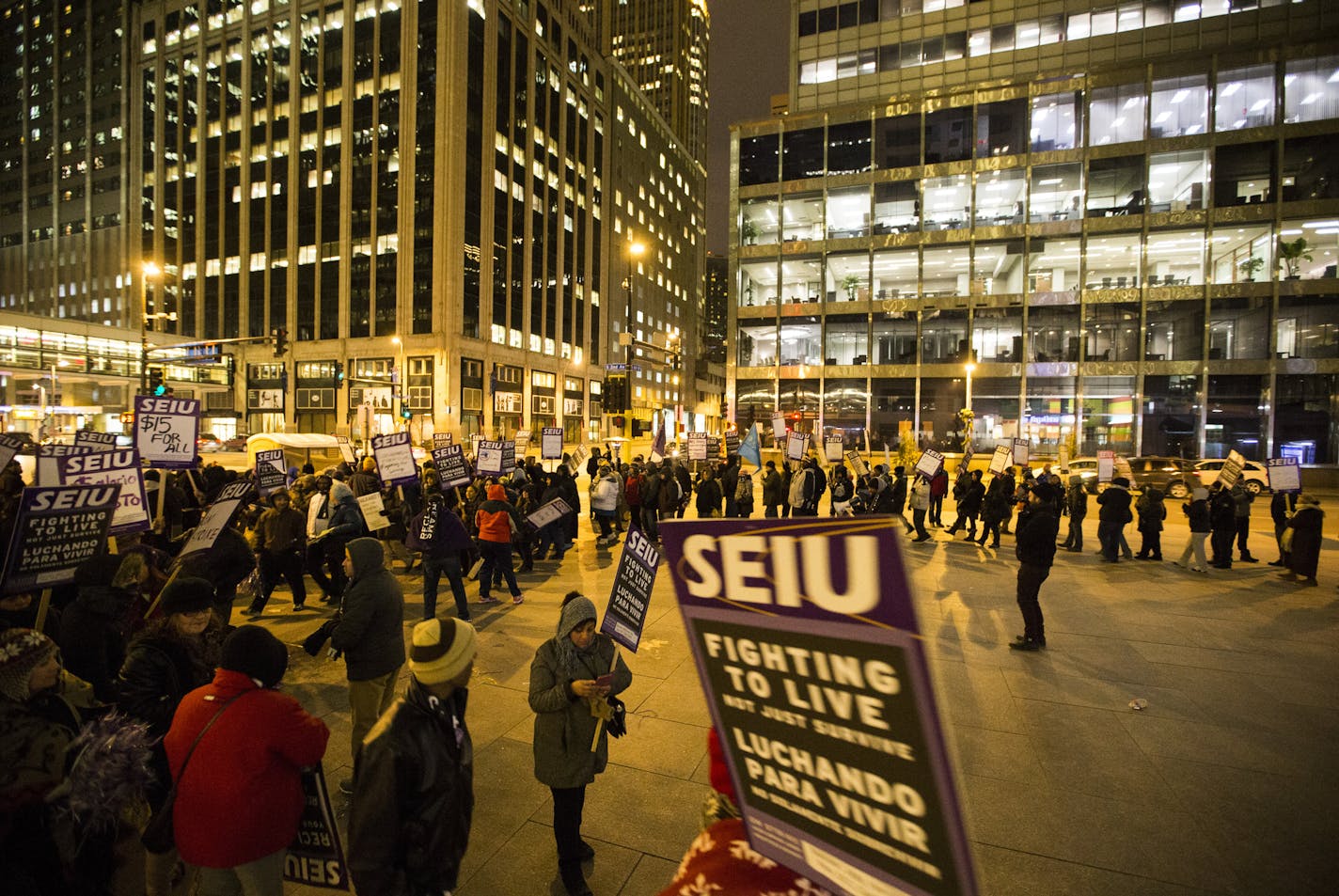 People walked holding signs in a circle during a one-day protest for local janitors outside the U.S. Bank building on Wednesday, February 17, 2016, in Minneapolis, Minn. ] RENEE JONES SCHNEIDER &#x2022; reneejones@startribune.com