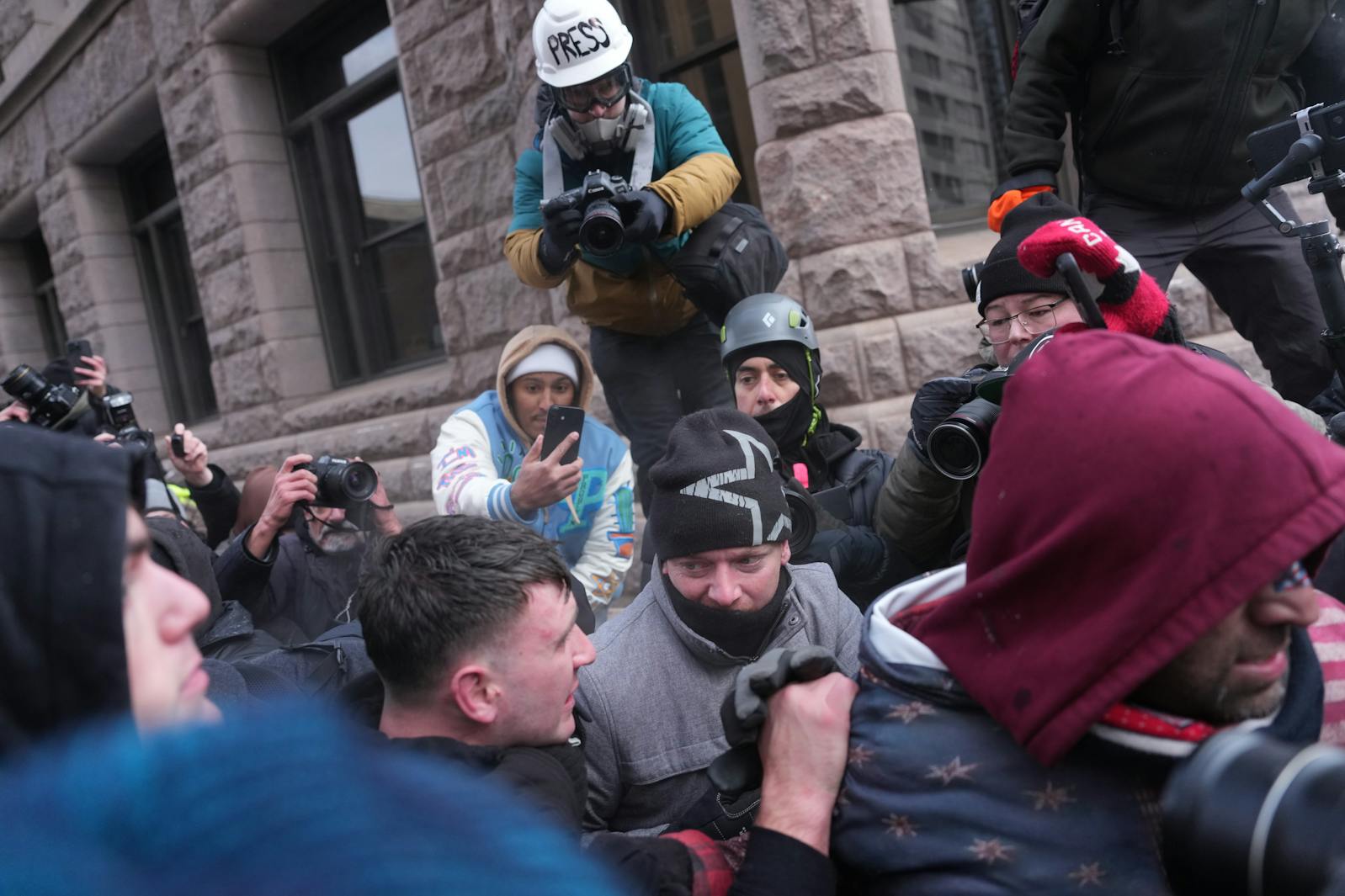 A chaotic scene interrupts between right-wing influencer Jake Lang and counterprotesters as he tries to leave a rally in Minneapolis Saturday, Jan. 17. 