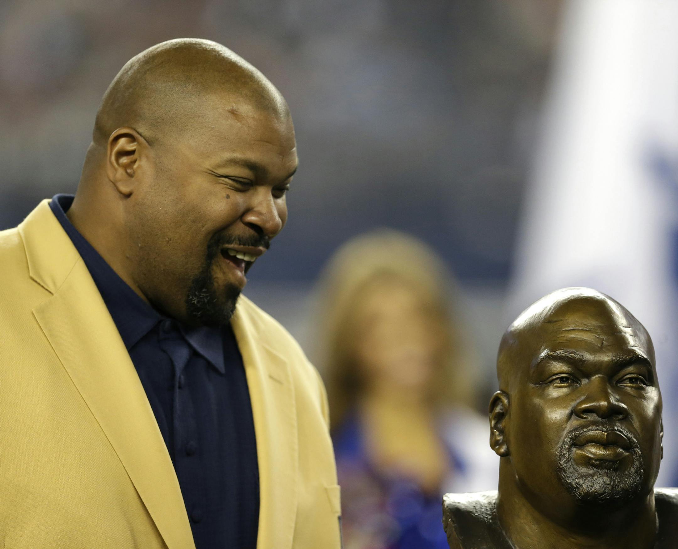 Former Dallas Cowboys player and Hall of Fame player, Larry Allen looks down at a bust of himself as Allen is honored at half time of an NFL football game against the Washington Redskins, Sunday, Oct. 13, 2013, in Arlington, Texas. (AP Photo/LM Otero) ORG XMIT: CBS148