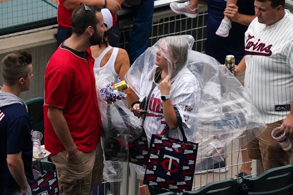 Fans donned rain gear as the rain drops started to fall Saturday afternoon at Target field just after it was announced the game against the Cleveland 