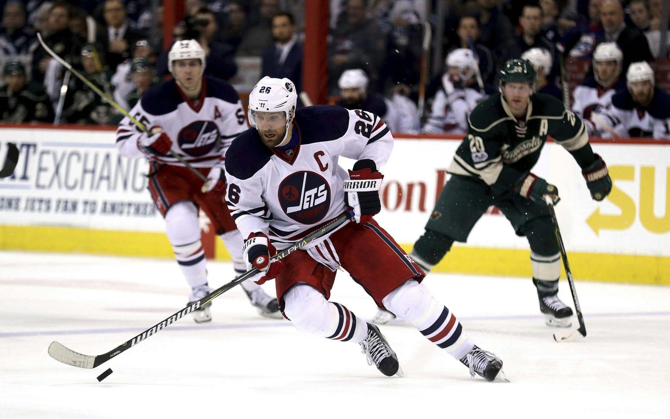 Winnipeg Jets' Blake Wheeler (26) carries the puck into the Minnesota Wild zone during the second period of an NHL hockey game in Winnipeg, Manitoba, Sunday, March 19, 2017.