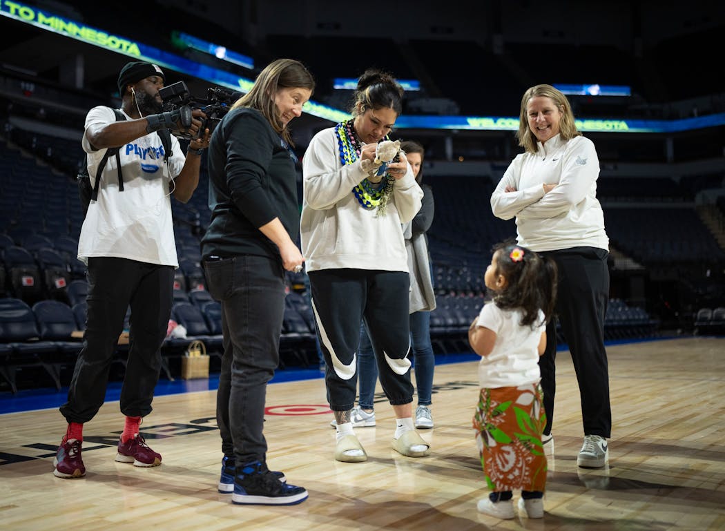 Alissa Pili signs a stuffed animal for fan Tala Hubbard, 2, while standing with Carley Knox, Lynx president of business operations, and head coach Cheryl Reeve, right. Tala's mom said Pili's presence in Minnesota will show her daughter that 