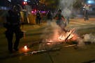 Minneapolis Police officers worked to extinguish a fire outside the Hennepin County Jail Thursday night.