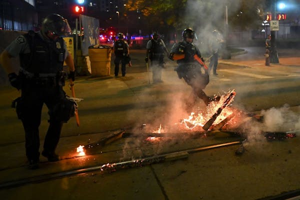 Minneapolis Police officers worked to extinguish a fire outside the Hennepin County Jail Thursday night.