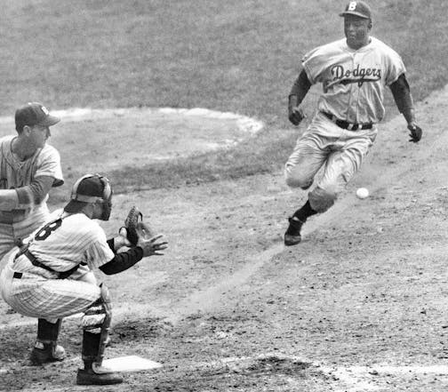 FILE Ñ New York Yankees catcher Yogi Berra covers the plate as Jackie Robinson of the Brooklyn Dodgers steals home in the opening game of the 1955 World Series at Yankee Stadium on Sept. 28, 1955. Dodgers pinch hitter Frank Kellert is at bat. Berra, one of baseballÕs greatest characters and a mainstay on 10 Yankees championship teams, died on Tuesday, Sept. 22, 2015. He was 90. (Meyer Liebowitz/The New York Times)