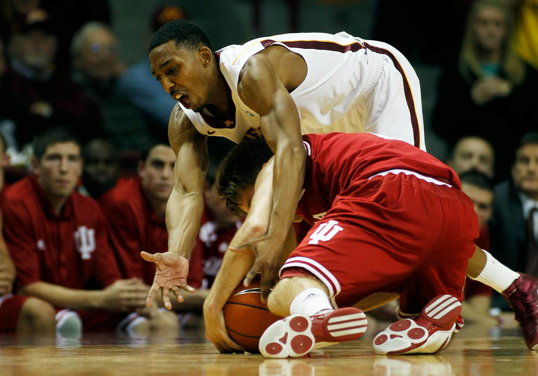 Gophers guard Al Nolen (top) tried to pry the ball loose from Indiana's Jordan Hulls.