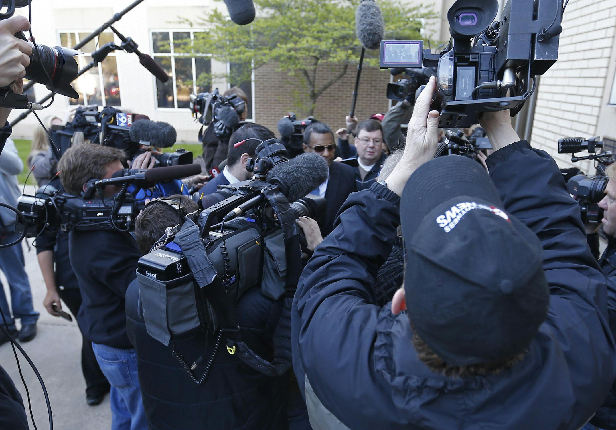 Alfred Jackson, center with sunglasses, the half-brother of Prince, is swarmed by photographers as he arrives at the Carver County Courthouse Monday, May 2, 2016, in Chaska, Minn., where a judge has confirmed the appointment of a special administrator to oversee the settlement of Prince's estate. The pop rock singer died on April 21 at the age of 57. (AP Photo/Jim Mone)