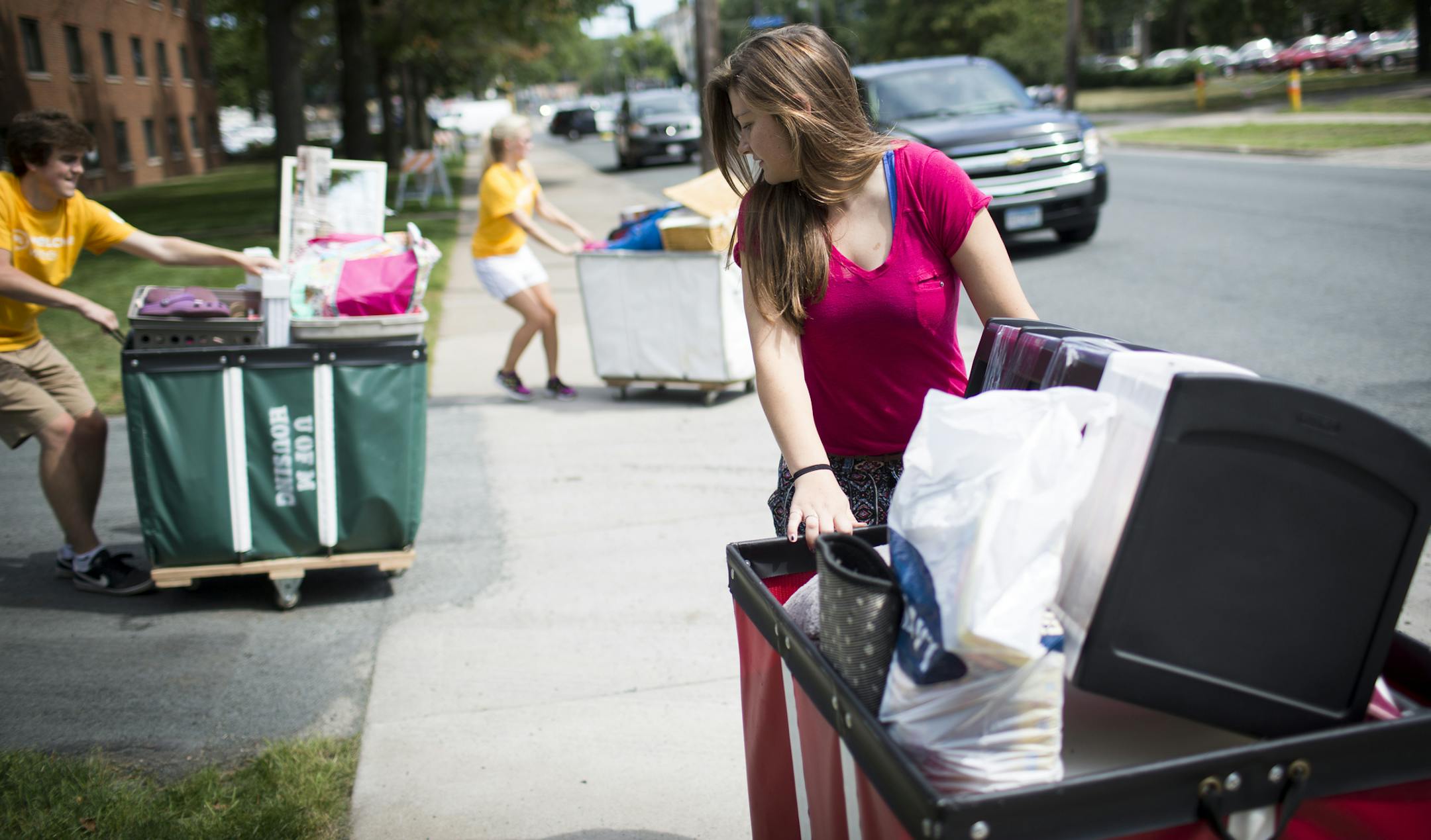 Rachel Berg, 18, from Duluth got help from volunteers as she carted in three carts of her belongings during move in day for freshman at the University of Minnesota in Minneapolis, Minn. on Monday, August 25, 2014 ] RENEE JONES SCHNEIDER • reneejones@startribune.com