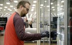 A Target employee in Tulsa cleans door handles. Target has stepped up safety measures at its stores. (Mike Simons/Tulsa World via AP)