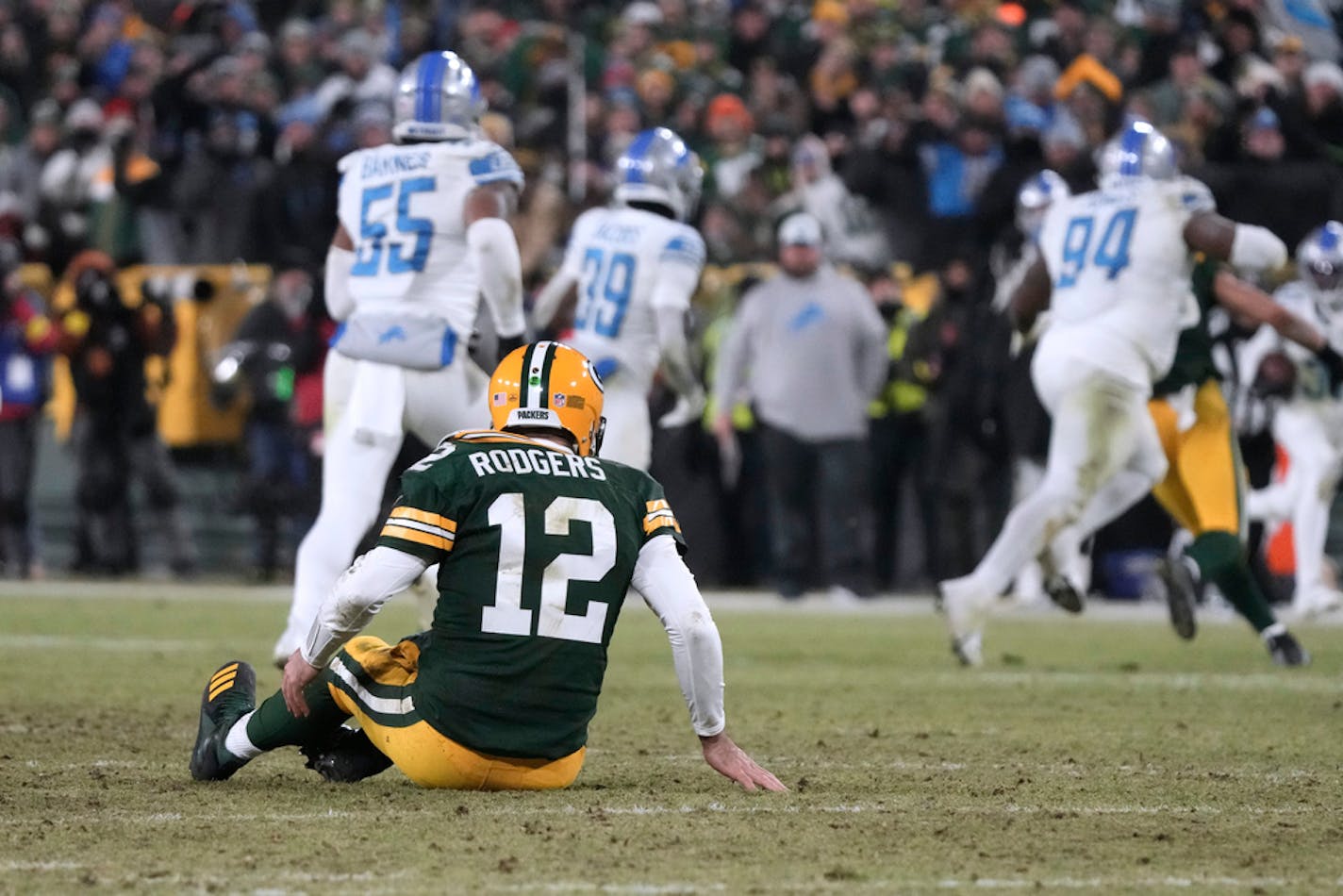 Green Bay Packers quarterback Aaron Rodgers sits on the turf after throwing an interception Sunday.