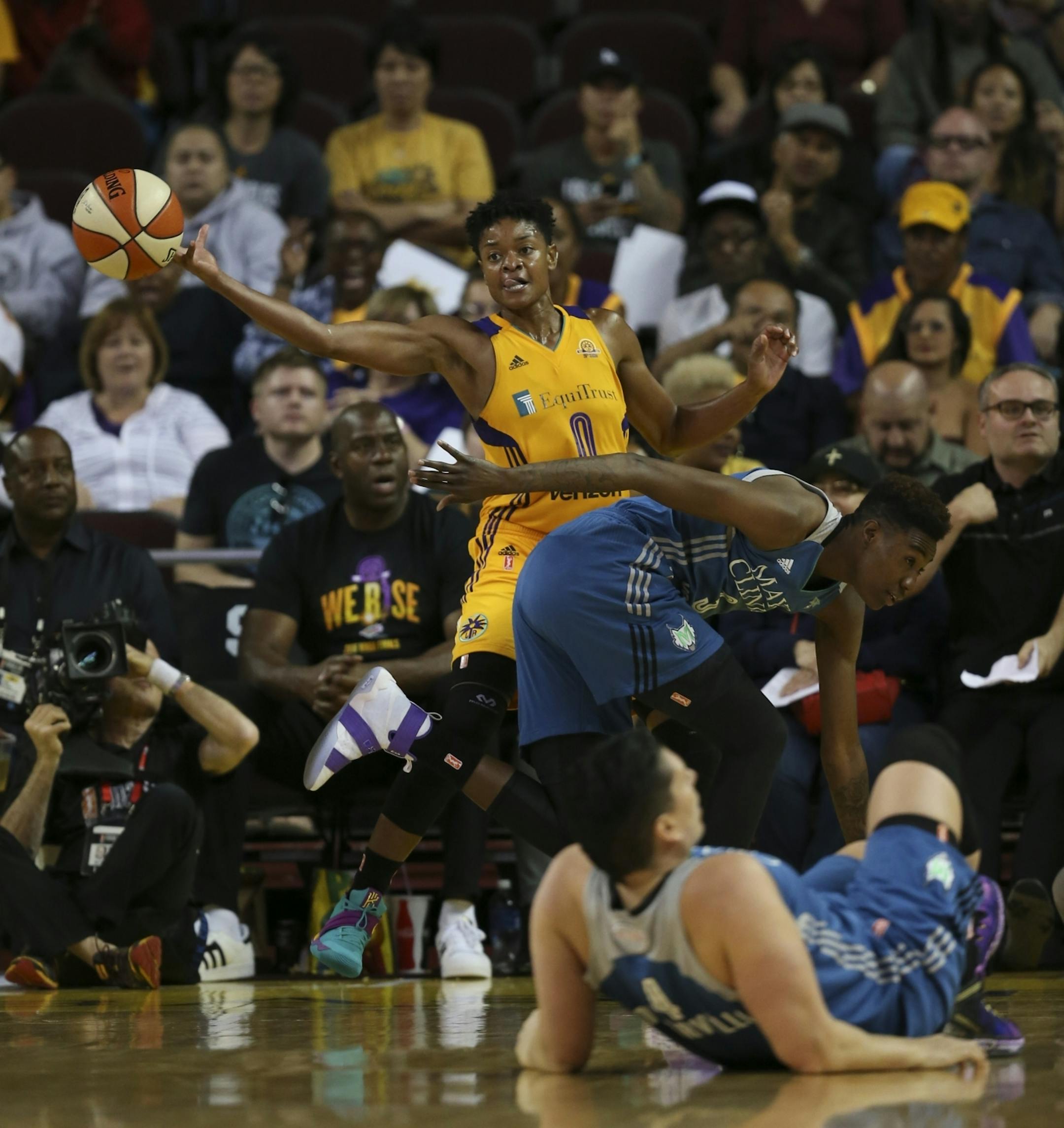 Los Angeles Sparks guard Alana Beard (0) and Minnesota Lynx forward Natasha Howard (3) continued play while Lynx center Janel McCarville (4) lay injured on the floor.