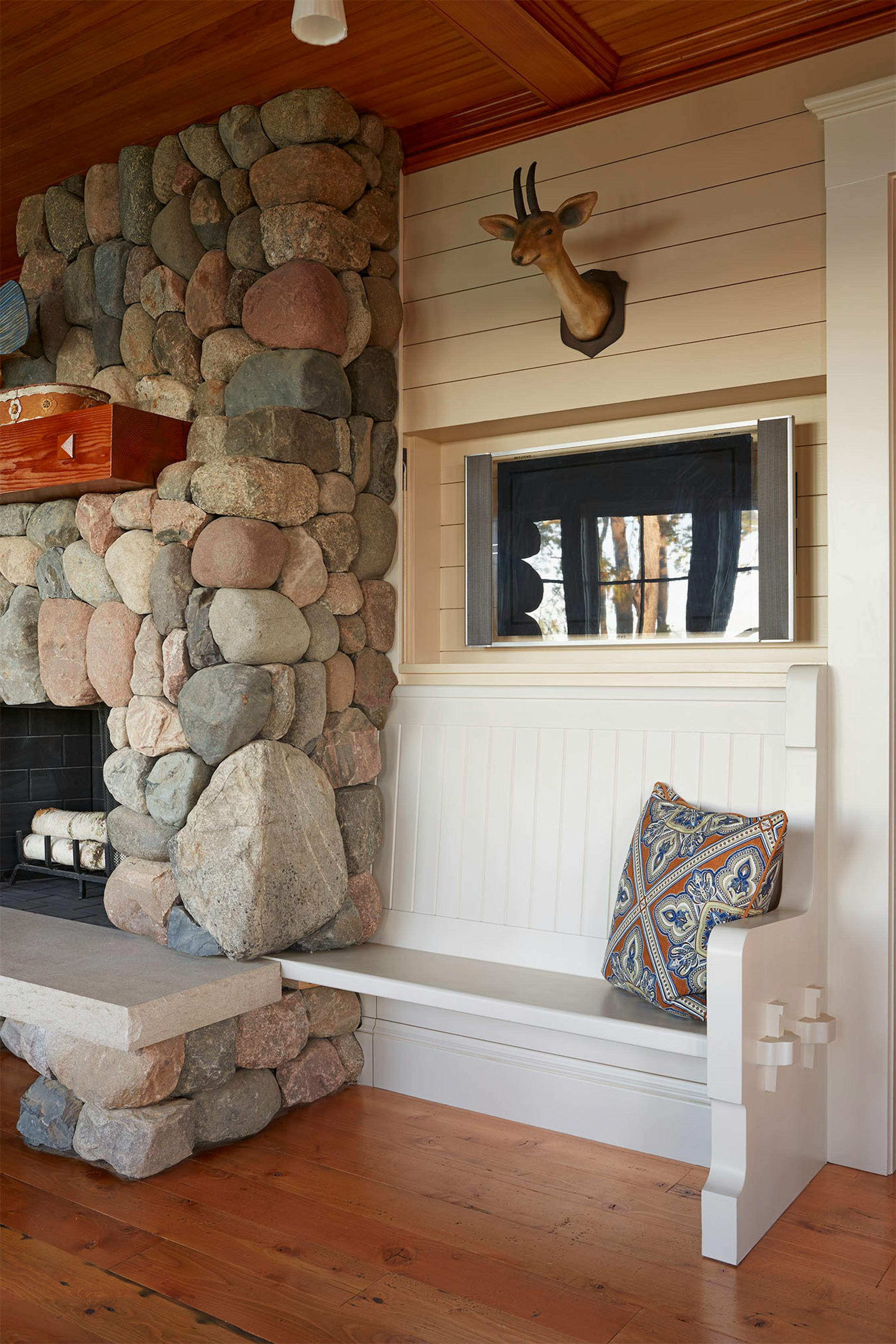 A flat screen TV is concealed behind a wall clad with shiplap boards in the living room.
