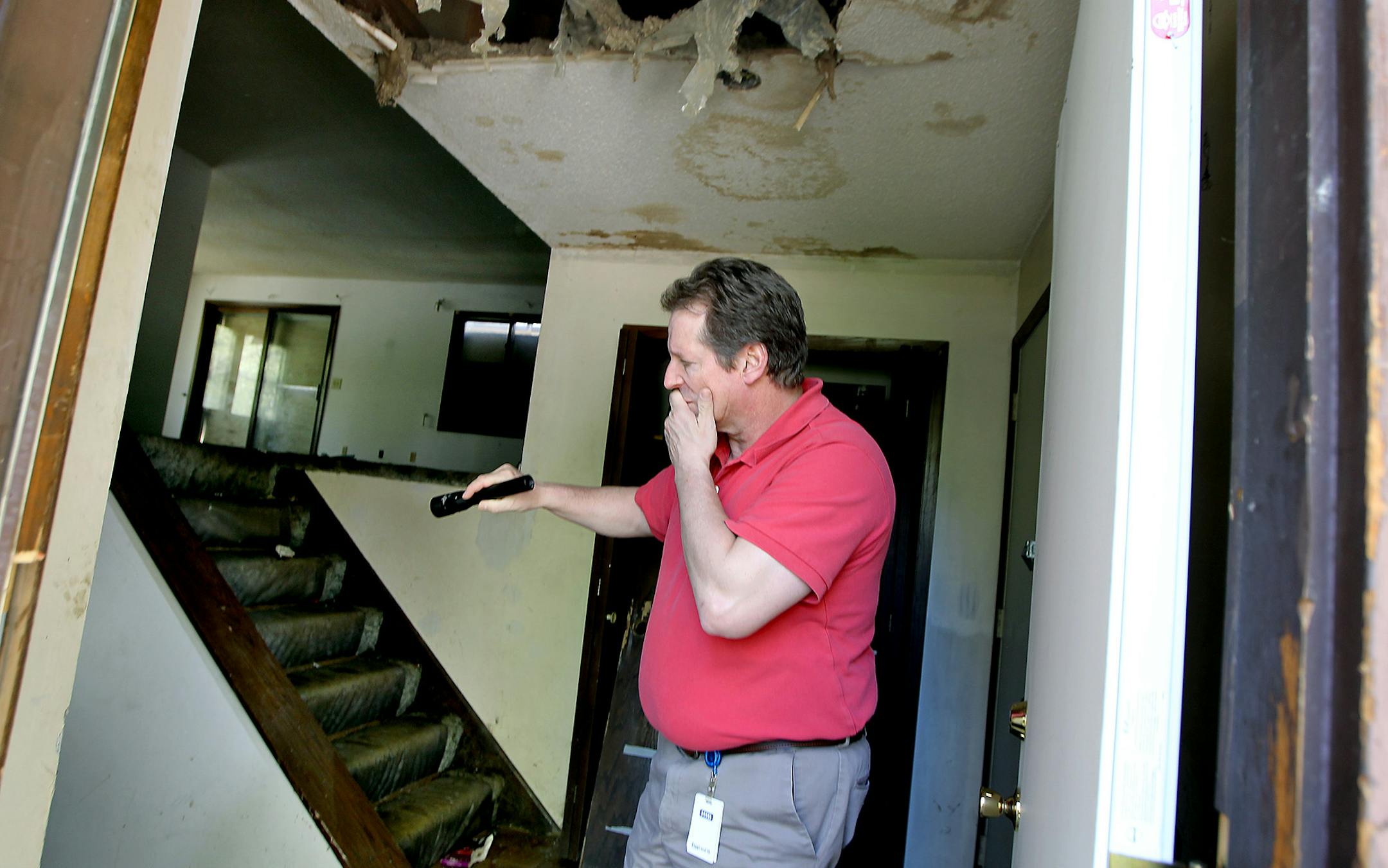 Coon Rapids Chief Building Official Greg Brady braced against the stench of the abandoned house, which will be torn down soon at city expense.