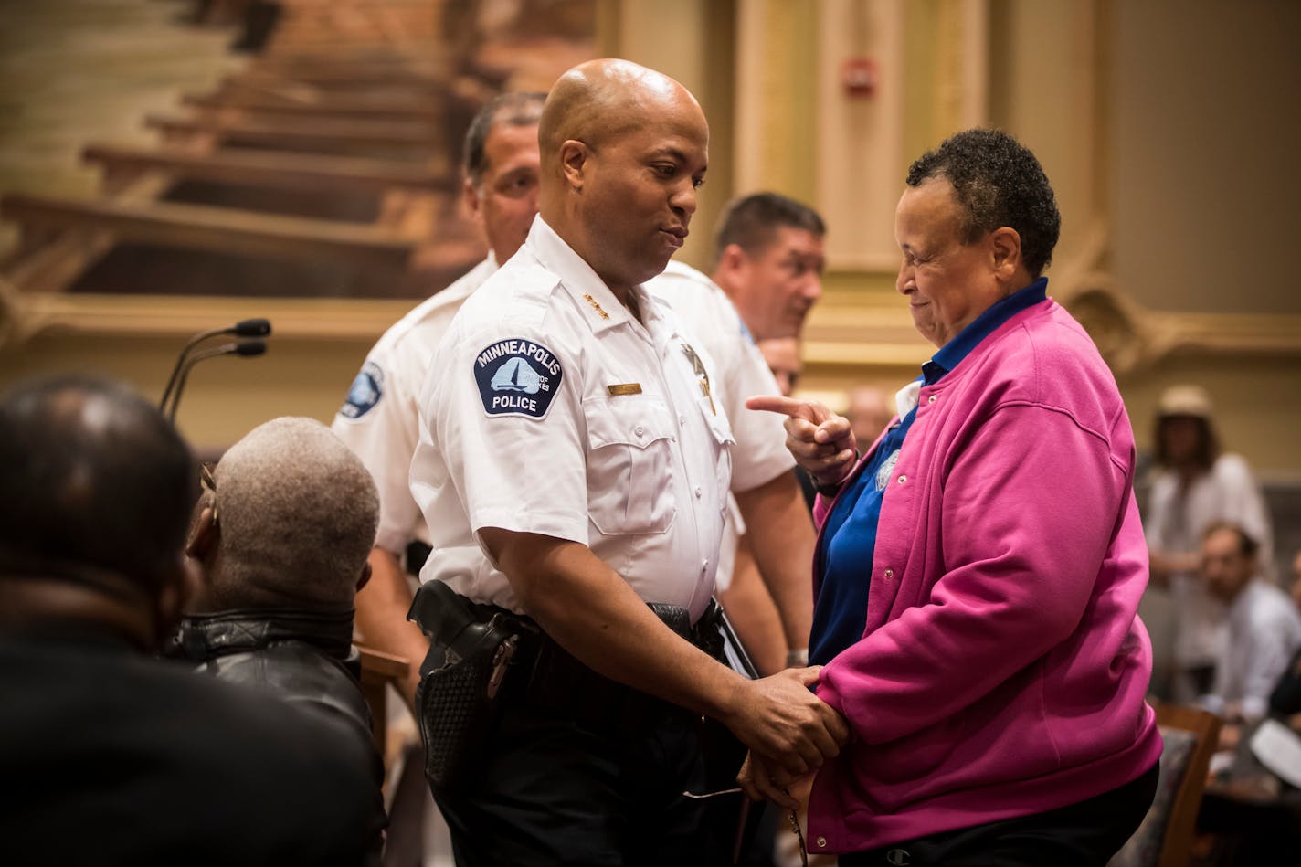 New Minneapolis Police Chief Medaria Arradondo chatted with Debby Montgomery, the first female officer in the St. Paul Police Department and former St. Paul City Council member, at a Friday city council meeting where he was voted to be chief.