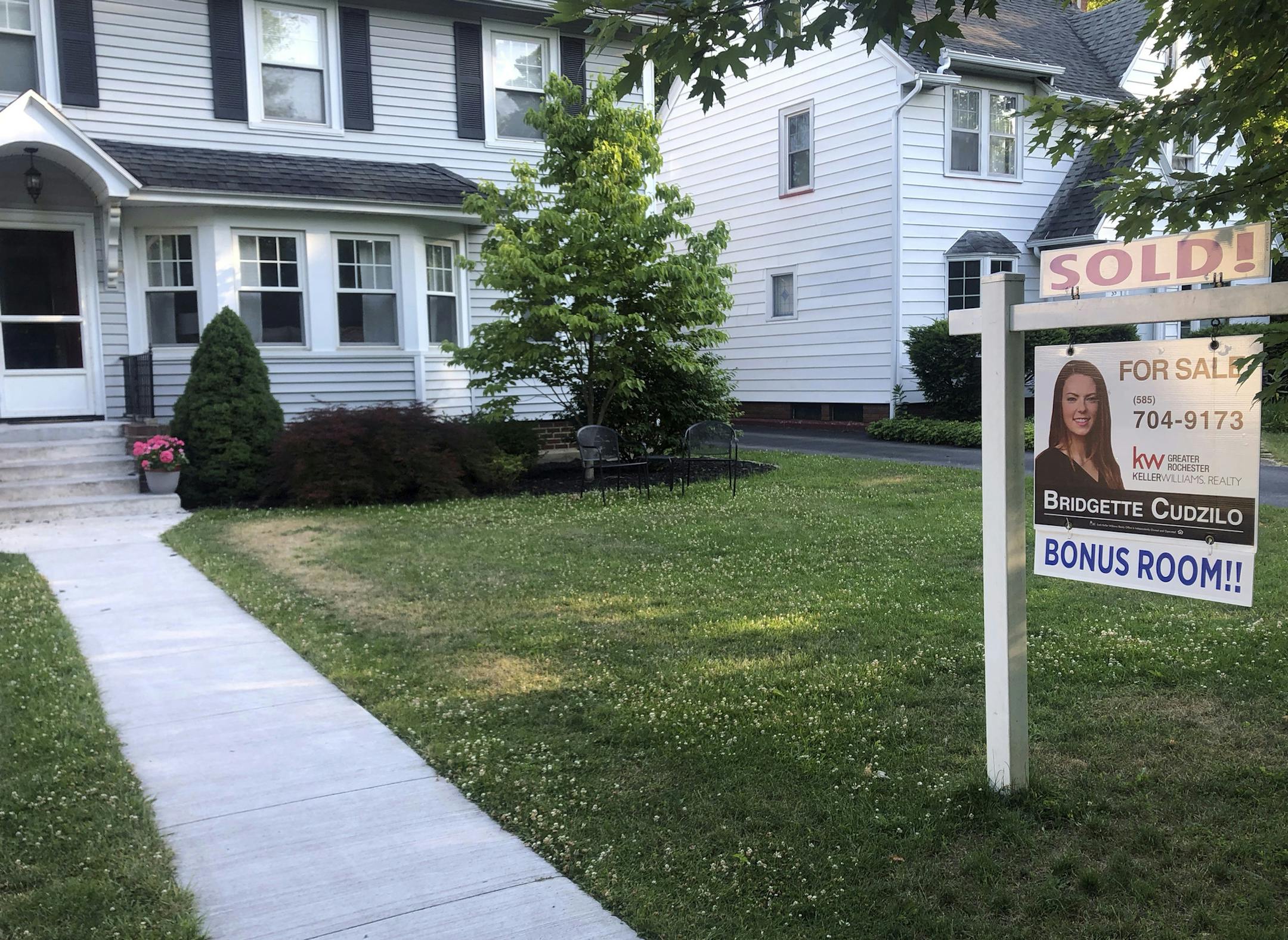 FILE - In this July 4, 2020 photo, a sold sign hangs in front of a house in Brighton, N.Y. More Americans signed contracts to buy homes in July, a sign that the hot housing market should continue into the fall season. (AP Photo/Ted Shaffrey)