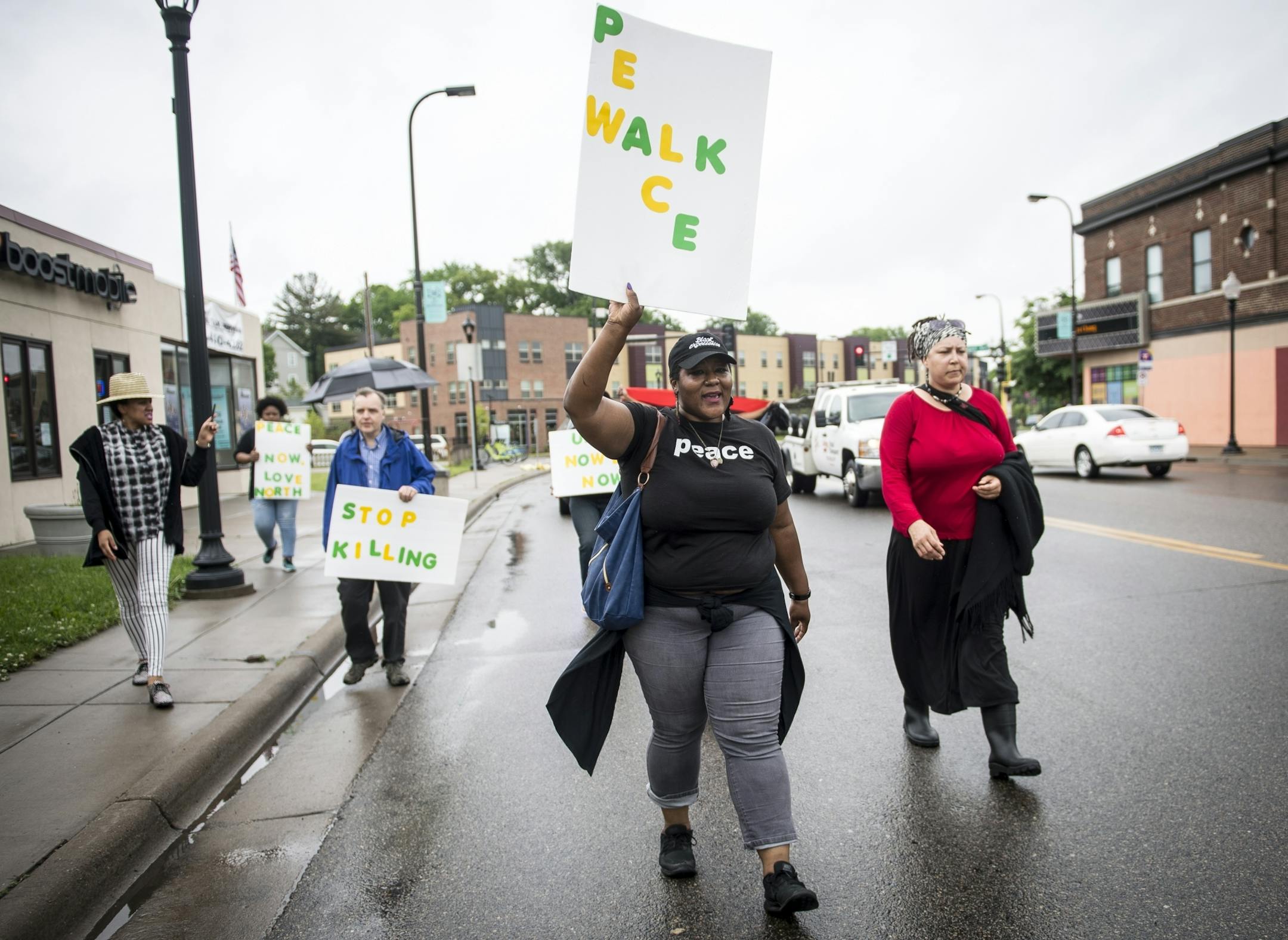 Community members were led along West Broadway Avenue during a peace walk in north Minneapolis by community activist, Shantae Peace, Friday afternoon.